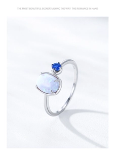Macro detail of S925 silver ring featuring oval opal and small blue gemstone accents