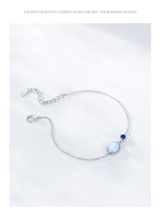 Detailed macro view of S925 silver bracelet featuring oval opal and blue gemstone
