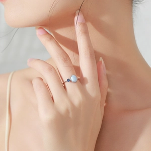 Elegant S925 sterling silver ring with blue opal and sapphire, worn on a female finger