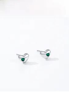 Gros plan détaillé des boucles d'oreilles cœur en argent S925 avec zircons verts