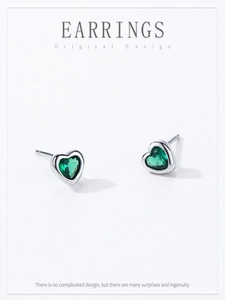 Detail of S925 silver heart stud earrings with emerald zircon on white background