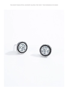 Detail of round S925 sterling silver halo studs with clear center and black accents