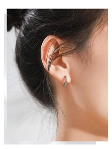 Close-up of minimalist S925 sterling silver huggie earrings with black zircon stones