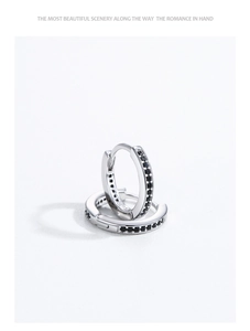 Macro view of S925 sterling silver hoop earrings with row-set black cubic zirconia stones