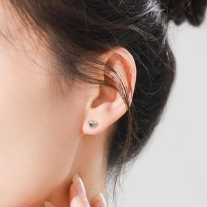 Élégantes boucles d'oreilles cœur en argent S925 avec zircon vert portées par un mannequin