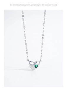 Close-up of S925 sterling silver necklace featuring a sparkling green heart-shaped pendant