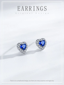 Detailed macro view of S925 silver heart stud earrings with blue sapphire cubic zirconia