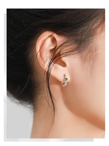 Gros plan sur boucle d'oreille en argent S925 avec émeraude et zircons brillants