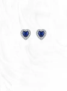 Macro shot of 925 silver heart stud earrings with blue sapphire and diamond halo