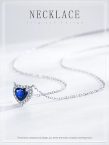 Macro detail of S925 sterling silver heart necklace with deep blue gemstone and zircon