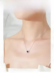 Blue heart pendant necklace in S925 sterling silver worn on a woman's collarbone
