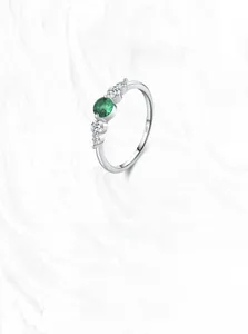 Macro shot of S925 sterling silver ring with emerald green stone and white zircon details