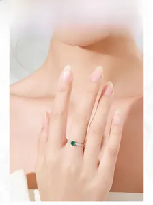 Detail of elegant S925 silver ring featuring a round green emerald stone on model hand
