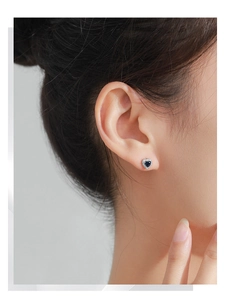 Close-up of 925 sterling silver heart-shaped stud earring with blue sapphire zircon