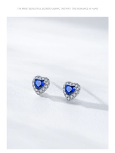 Macro detail of 925 silver heart stud earrings with blue sapphire cubic zirconia and halo