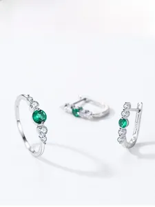 Close-up of S925 sterling silver jewelry set featuring emerald green gemstones and diamonds