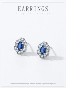 Detailed close-up of 925 sterling silver earrings with sapphire blue zircon accents
