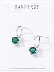 Close-up of S925 sterling silver earrings with round emerald green zircon in four-prong setting