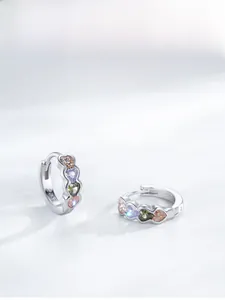 Vue macro des boucles d'oreilles en argent S925 avec quatre zircons coeurs multicolores