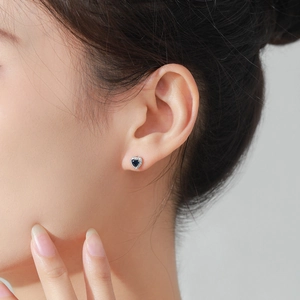S925 sterling silver heart stud earrings featuring blue zircon and white diamonds on model
