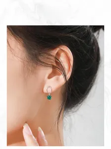 Elegant S925 sterling silver emerald stud earring worn by model in a close-up profile shot