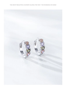 Détail macro de boucles d'oreilles en argent S925 avec quatre zircons colorés en cœur