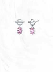 Detail showing 925 silver O-T buckle earrings with pink oval zircon on marble background