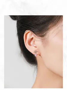 Model wearing 925 silver earring with pink zircon drop and minimalist O-T toggle design