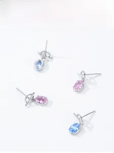 Detail of oval-cut pink and blue gemstones set in 925 sterling silver minimalist earrings