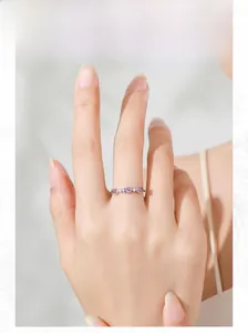 Detail of S925 silver ring featuring purple oval zircons and white crystals on finger