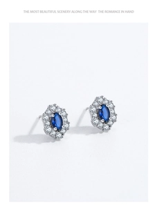 Macro view of vintage 925 silver stud earrings with oval blue sapphire and white crystals