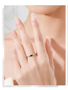 Gros plan d'une bague en argent 925 avec pierre bleue et diamants sur une main