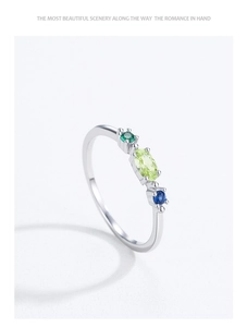 Gros plan sur une bague en argent 925 avec une pierre verte ovale et gemmes colorées