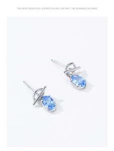 Macro view of 925 silver stud with oval blue zircon and minimalist O-ring T-buckle