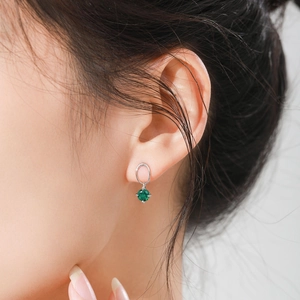 Elegant S925 sterling silver emerald earrings with round green zircon stones on model