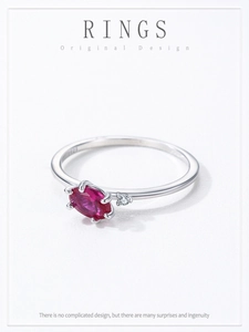 Detail of S925 hallmark on the silver band with red oval gemstone and accent stone