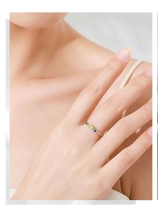 Detailed view of sterling silver ring with inset olive green and blue sapphire zircon gems