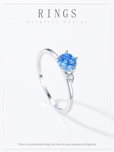 Dettaglio di un anello in argento 925 con zircone blu rotondo e pietra laterale d'accento