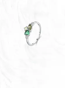 Detail showing S925 hallmark and vibrant green zircon insets on silver ring band