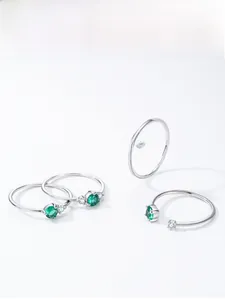 Detailed close-up of S925 silver rings with emerald green stones and diamond accents