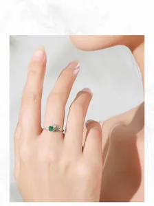 Close-up model shot of vintage 925 sterling silver ring with green cubic zirconia stones