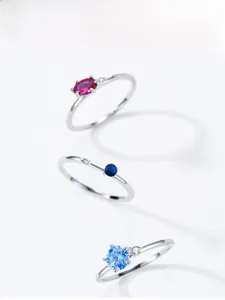 Detail view of 925 sterling silver rings with red and blue zircon stones in claw settings