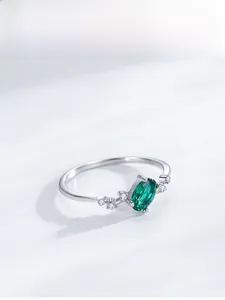 Macro shot of 925 sterling silver ring with oval green gemstone and zircon accents