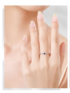 Dettaglio dell'anello in argento 925 con zircone blu sulla mano di una modella