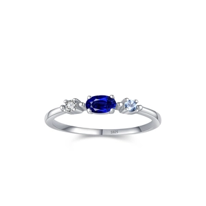 925 silver ring featuring blue oval center stone and two side gems in a classic three-stone design