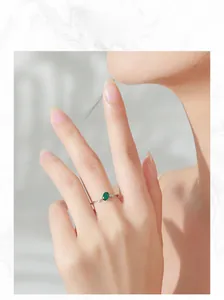 Primo piano di un anello in argento 925 con smeraldo ovale e piccoli diamanti laterali