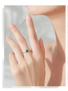 Detail of 925 silver ring featuring an oval green gemstone and side cubic zirconia