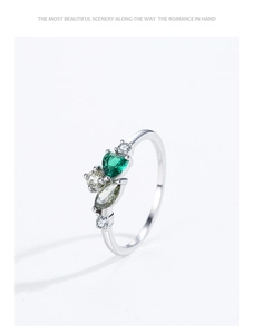 Detail of 925 silver ring featuring heart and marquise cut green zircon stones