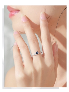 Primo piano anello in argento 925 con gemma blu ovale e piccoli diamanti brillanti