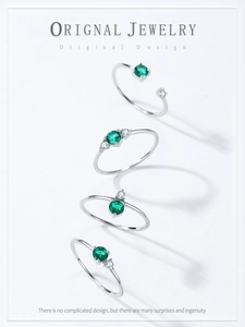 Close-up of four vintage S925 silver rings with emerald green zircon gemstones